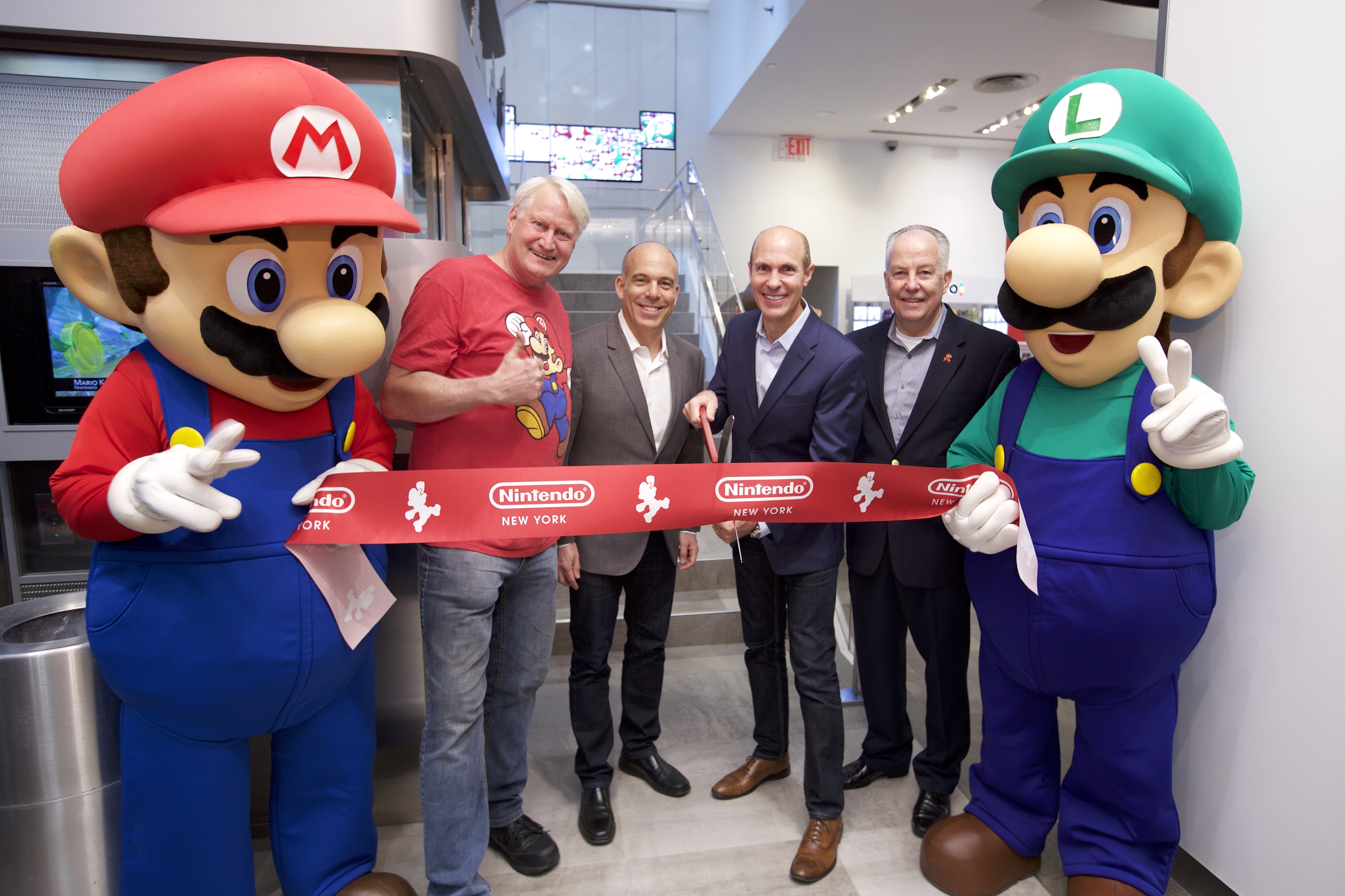 In this photo provided by Nintendo of America, Mario and Luigi unveil the remodeled Nintendo NY store during a ribbon-cutting ceremony on 19th February 2016. Joining the Super Mario Bros. (left to right) are Charles Martinet, the voice of Mario, and Nintendo of America executives Doug Bowser, Vice President of Sales; Scott Moffitt, Executive Vice President of Sales & Marketing; and Rick Lessley, Vice President of the Supply Chain Group.​